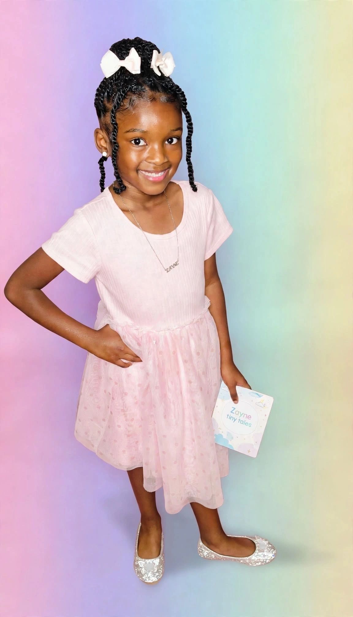 Zayne, the young author of Zayne's Tiny Tales, holding one of her books